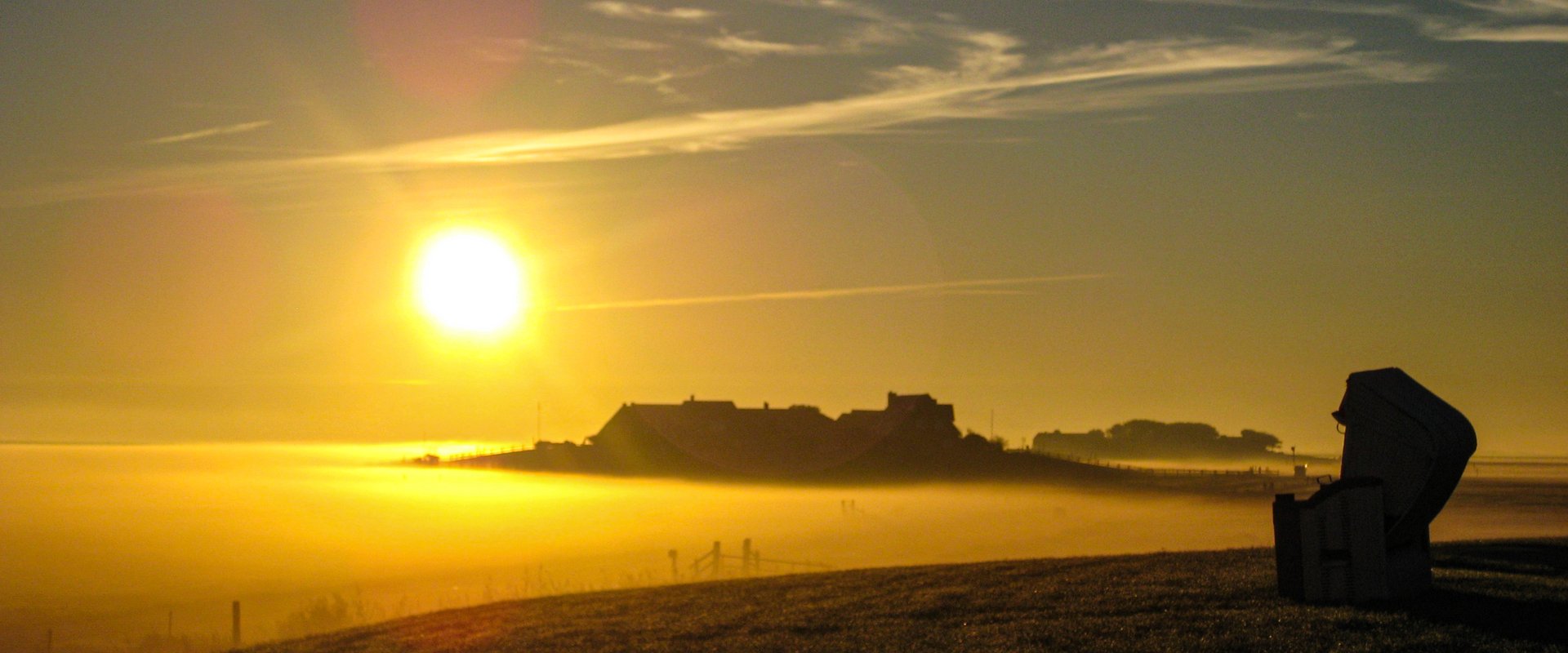 Strandkorb im Licht des Sonnenaufgangs mit Blick von Mitteltritt nach Ockelützwarft und Hanswarft