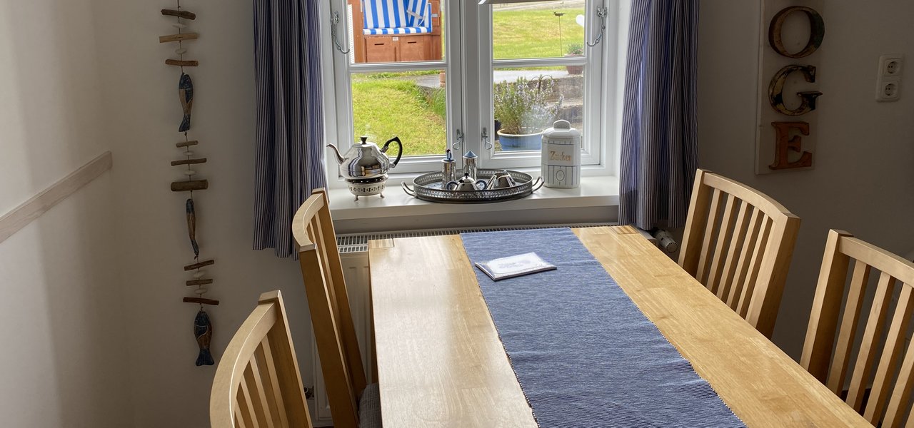 Wohnung Dree Essbereich und Blick durchs Fenster auf einen Strandkorb