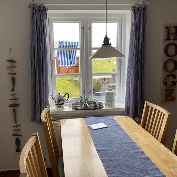 Wohnung Dree Essbereich und Blick durchs Fenster auf einen Strandkorb