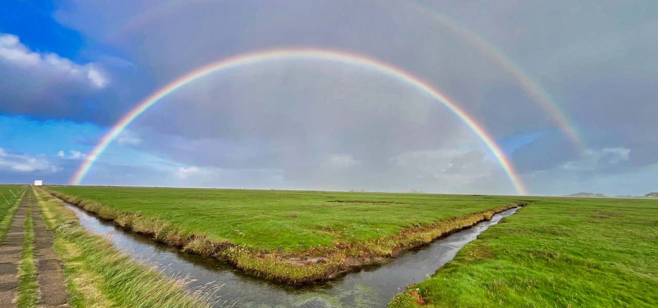 Blick über die Hallig mit doppeltem Regenbogen